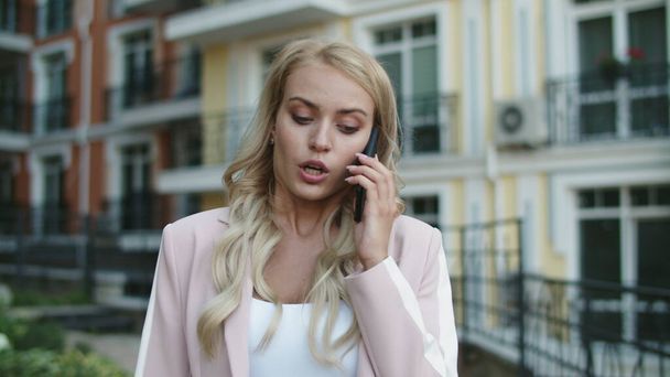 Portretowa bizneswoman rozmawiająca przez telefon na ulicy. Kobieta kłóci się przez telefon na zewnątrz - Zdjęcie, obraz