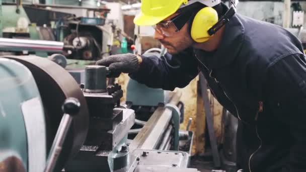 Älykäs tehtaan työntekijä, joka käyttää konetta tehdastyöpajassa - Materiaali, video