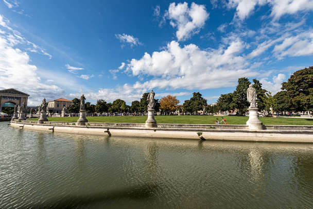 Prato della Valle, διάσημη πλατεία της πόλης στην Padua στο κέντρο της πόλης, μία από τις μεγαλύτερες στην Ευρώπη. Βένετο, Ιταλία. Πρόκειται για ένα ωοειδές τετράγωνο με 78 αγάλματα, 4 γέφυρες και ένα νησί.. - Φωτογραφία, εικόνα