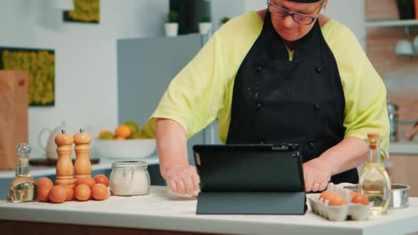 Γυναίκα σεφ χρησιμοποιώντας δισκίο στην κουζίνα - Πλάνα, βίντεο