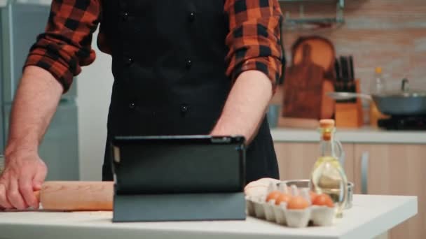 Μπέικερ χρησιμοποιώντας ταμπλέτα μαγείρεμα σπίτι κέικ - Πλάνα, βίντεο