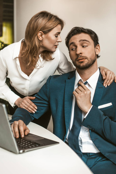 Female Head of office embraced the male employee working at his workplace. Seducing a subordinate in the office. High quality photo - Foto, imagen