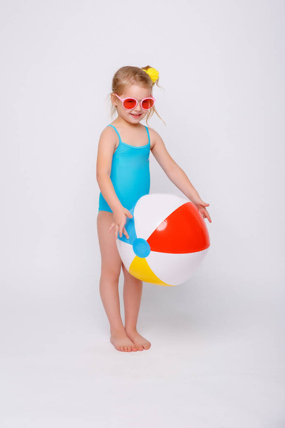 Cute smiling little girl in swimsuit with rubber ring isolated on a white. Fashionable little girl in swimsuit. - Zdjęcie, obraz