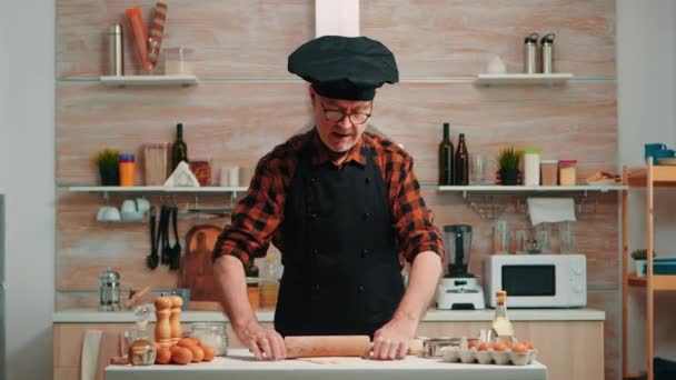 Reifer Mann bereitet Pizza am Küchentisch zu - Filmmaterial, Video
