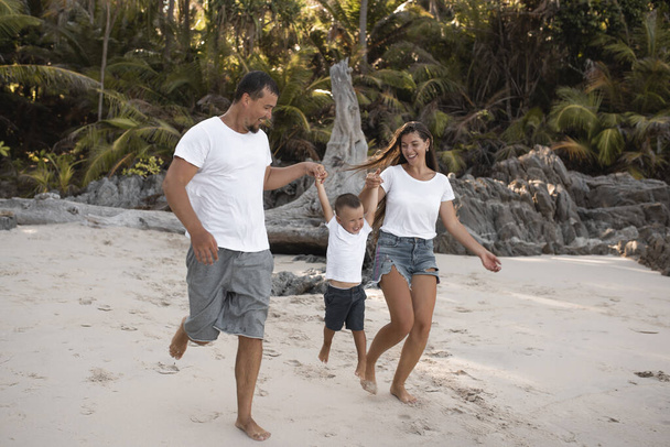 Ευτυχισμένο χαμόγελο Ευρωπαϊκή οικογένεια έχουν ξεκουραστεί και να τρέξει σε λευκή άμμο παραλία - Φωτογραφία, εικόνα