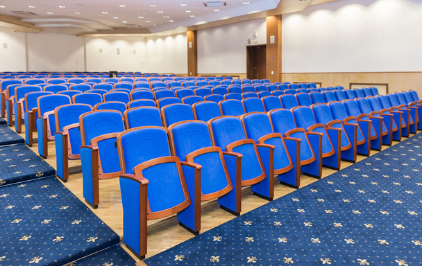 Sala de conferencias con asientos azules
 - Foto, imagen