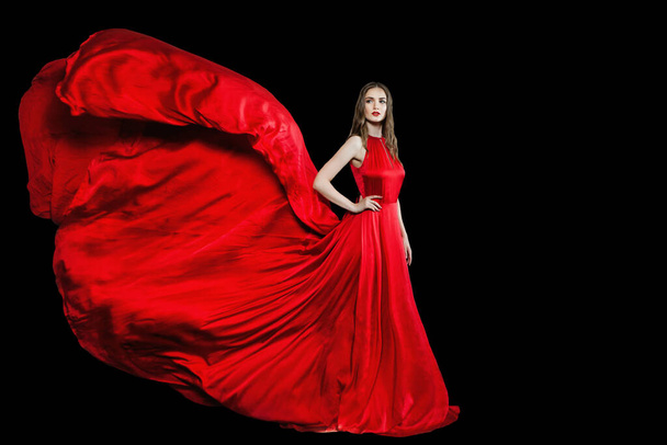 Mulher modelo atraente em vestido de noite sedoso vermelho de pé isolado no fundo preto - Foto, Imagem