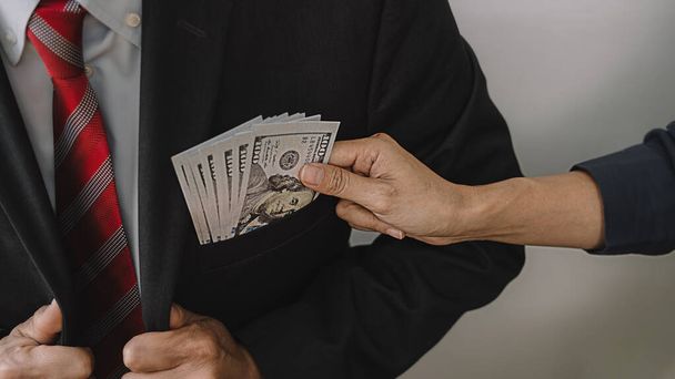 Businessman giving money while making deal to agreement a real estate contract and financial corporate.Bribery and corruption concept - Photo, Image