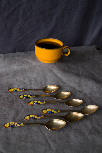 Vintage spoons, silverware and black coffee cup - Photo, Image