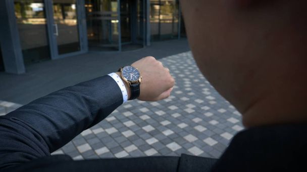 closeup designer watch on businessman hand, he looks on the time and hurrying - Valokuva, kuva