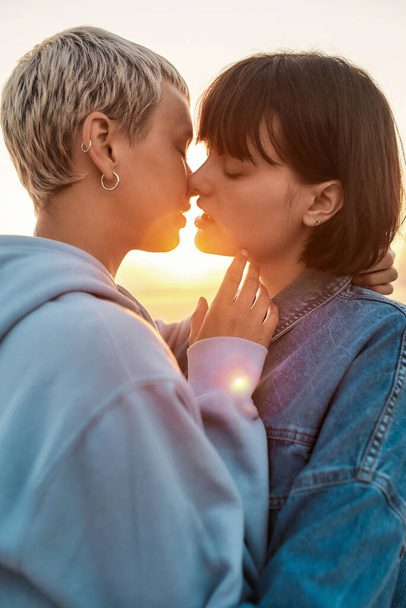 Young lesbian couple having romantic moment, Two women going to kiss while watching the sunrise together, Selective focus - Foto, Imagem