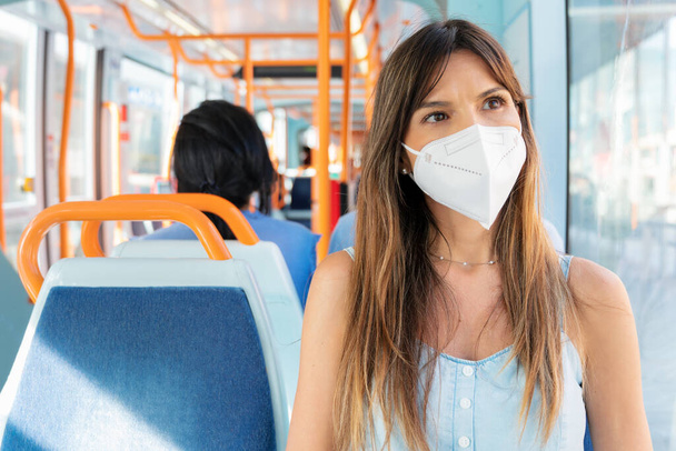 Young Woman Wearing a Face Mask Riding Public Transport - Foto, imagen