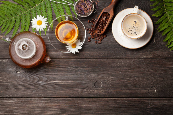 Herbal tea in teapot and cup and espresso coffee on wooden table. Top view with copy space. Flat lay - Photo, Image