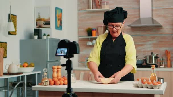 Oude vrouw opnemen van voedsel video in de keuken - Video