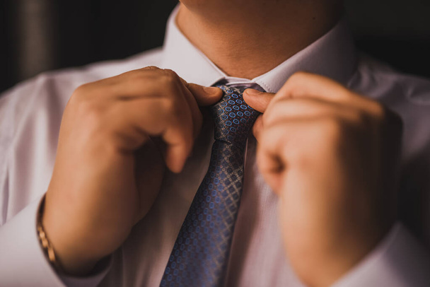 Mann im weißen Hemd richtet seine Krawatte auf - Foto, Bild