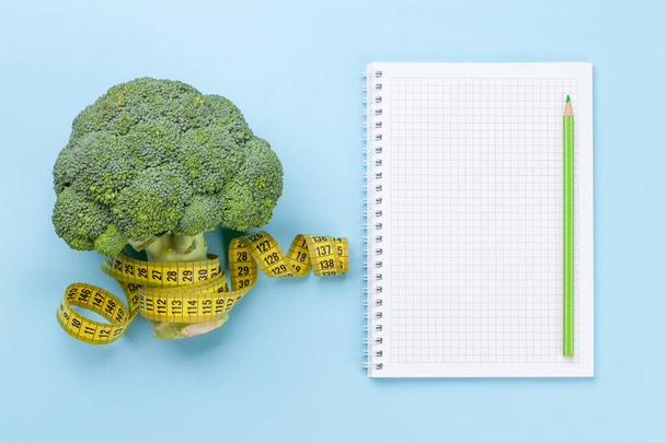 Broccoli and tape measure. Healthy food and weigh loss concept. Diet and fitness. Top view flat lay with copy space - Photo, Image