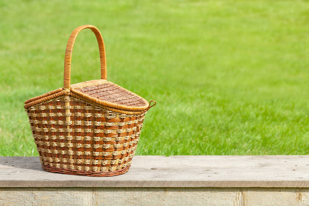 Picnic basket on garden table. With copy space - Foto, Imagem
