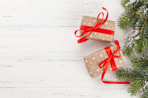Cajas de regalo de Navidad y abeto sobre fondo de madera con espacio para sus saludos. Vista superior plano laico - Foto, Imagen