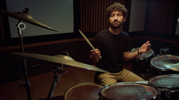 Musiker, der Rockmusik im Studio spielt. Schlagzeuger schließt Augen im Konzertsaal. - Foto, Bild