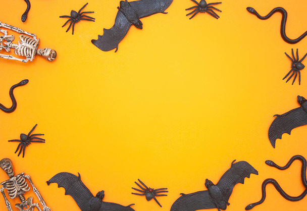 Halloween flatlay with skeletons,bats,spiders and snakes on  background, empty space for text, scary holiday concept, autumn horror stories. - Fotó, kép