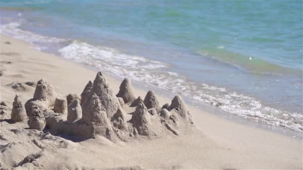 Zandkasteel op wit tropisch strand met plastic kinderspeelgoed - Video