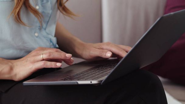 Kobiece ręce na laptopie w odległym biurze. Dziewczyna pracująca nad notatnikiem. - Zdjęcie, obraz