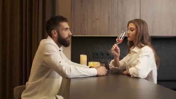 Βαρετό, προσβεβλημένο ζευγάρι να πίνει σαμπάνια στην κουζίνα στο σπίτι. άντρας και γυναίκα δεν μιλάνε μεταξύ τους. - Πλάνα, βίντεο