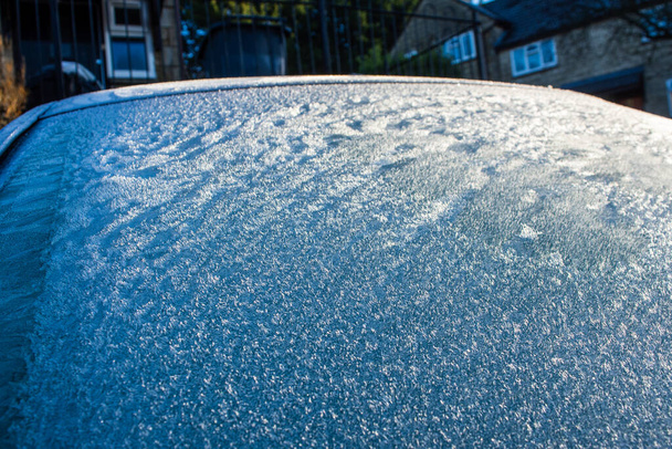 Cristales de hielo de las heladas que aparecen como "piel" o "hierba" en el parabrisas de un coche en una fría mañana de invierno - Foto, imagen