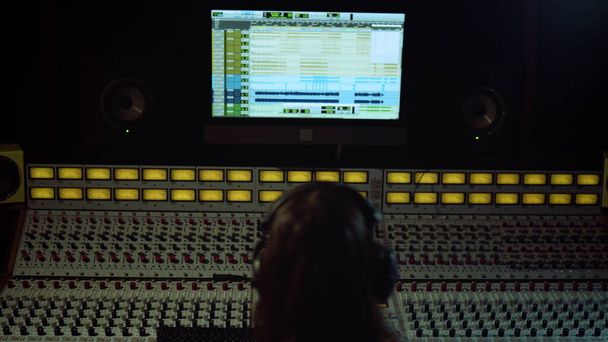 Unrecognizable sound engineer touching soundboard in recording music - Photo, Image