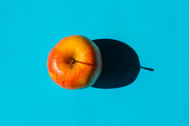 an Apple with a hard shadow on a plain background. the view from the top. blank for the pattern - Fotografie, Obrázek