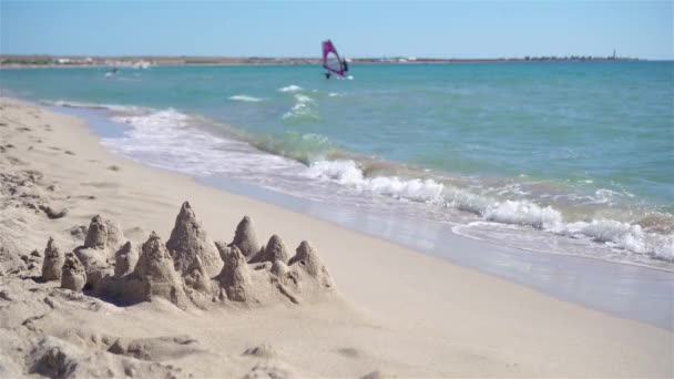 Castillo de arena en la playa tropical blanca con juguetes de plástico para niños - Imágenes, Vídeo