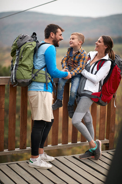 Happy couple with a son on a hiking adventure; Spring or autumn hiking in nature; camping, travel, tourism,lifestyle,  hike and people concept. Quality active family time together. - Φωτογραφία, εικόνα
