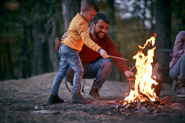Father and son starting a fire together on a camping; Quality family time concept - Fotografie, Obrázek