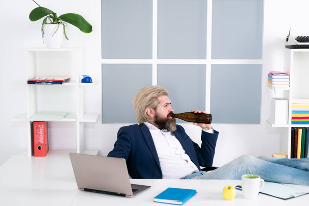 Alcoholism. Business and stress concept - drunk businessman drinking alcohol in office. End of the working day. - 写真・画像