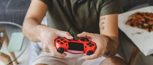 Happy man playing online video games - Young gamer having fun on new technology console - Gaming entertainment and youth millennial generation lifestyle concept - Photo, Image