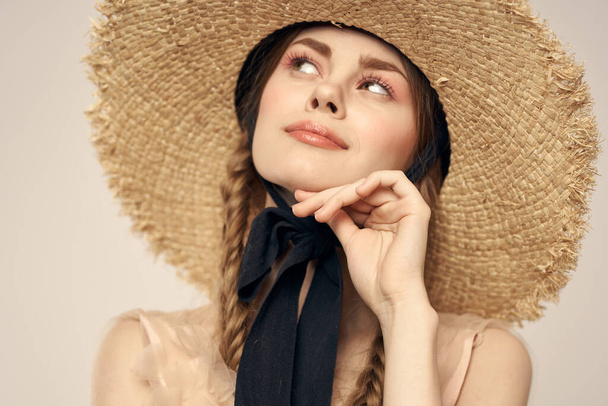 Nice girl in a straw hat with a black ribbon and in a dress on a light background romance model fun emotion - Foto, immagini