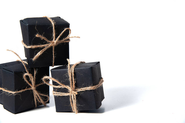 Pyramid of black handmade gift boxes tied with craft thread. Isolated. closeup. smart gift concept. copy space - Photo, Image