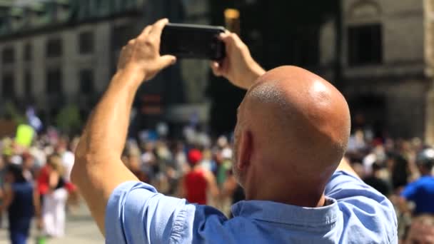 Hombre calvo tomando video de protesta usando móvil - Imágenes, Vídeo