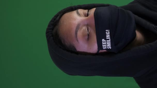 Adolescente feminina usando capuz e trazê-lo em 2021 máscara facial. Vídeo vertical, trancado fora, Tela verde - Filmagem, Vídeo