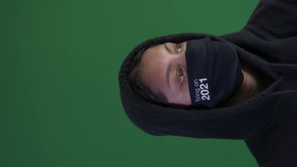 Aziatisch vrouw tiener dragen Hoodie en breng het op 2021 gezicht masker. Verticale video, Groen scherm, Afgesloten - Video