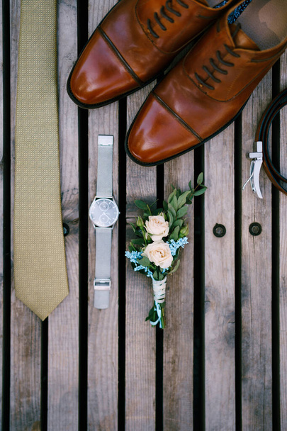 Détails de mariage du marié - boutonnière, chaussures, cravate et montre sur un fond en bois, vue sur le dessus. - Photo, image