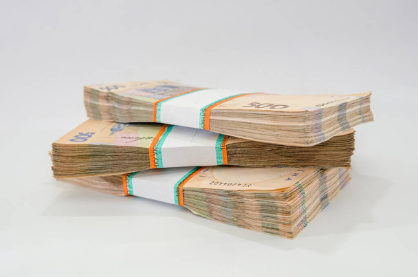 Beyaz arka planda izole edilmiş bir yığın Ukrayna parası, yığınla Hryvnia, 200 500 dolar para konsepti. Bir sürü banknot. Yan görünüm. - Fotoğraf, Görsel