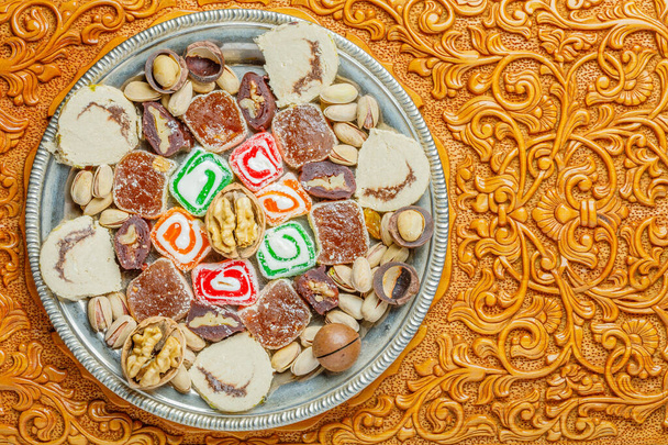 Ассорти традиционных восточных турецких деликатесов и орехов на деревянном фоне - Фото, изображение