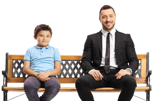 Businessman and a boy sitting on a bench isolated on white background - Fotografie, Obrázek