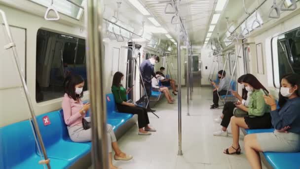 Multitud de personas que usan mascarilla facial en un concurrido tren público de metro - Imágenes, Vídeo