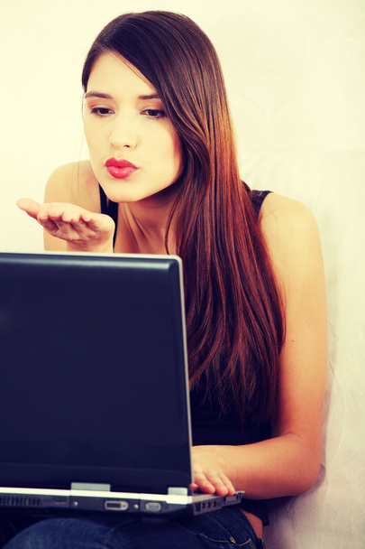 Young woman's sending kiss to laptop. - Foto, Bild