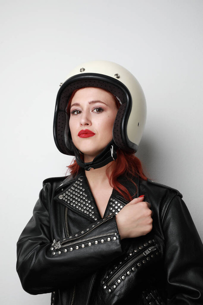Vertical portrait of young woman with a motorcycle helmet posing over isolated white background celebrating a victory. - Zdjęcie, obraz