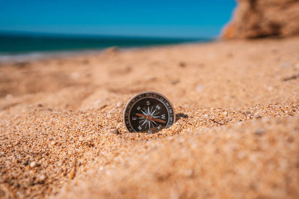 Háttérképe iránytű feküdt a homokban a tengerparton, kilátással a tengerre, utazási koncepció - Fotó, kép