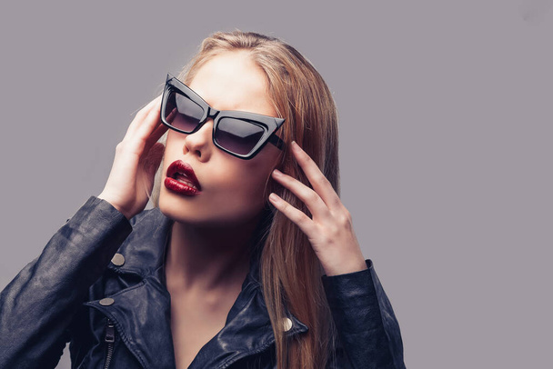 Fashion portrait of young elegant woman in black leather jacket, sunglasses - 写真・画像