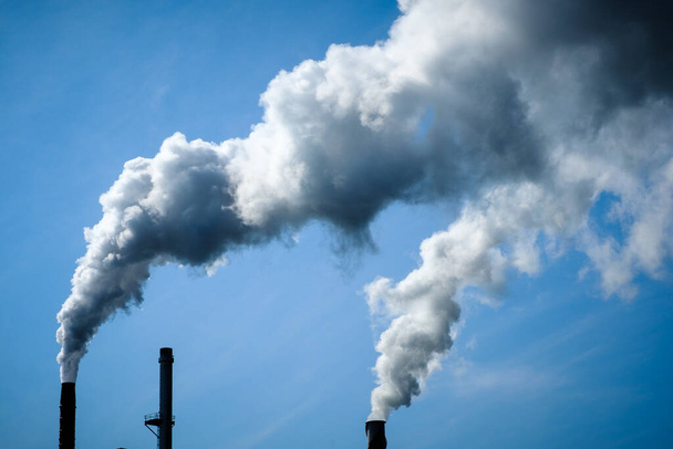Chmury zanieczyszczenia powietrza dymem przemysłowym i błękitnym niebem - Zdjęcie, obraz
